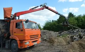 Ломовоз перекладывает древесные отходы